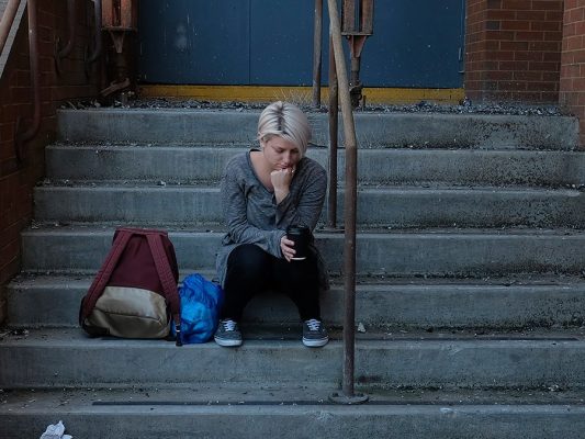 Stock image of a woman sitting on concrete stairs