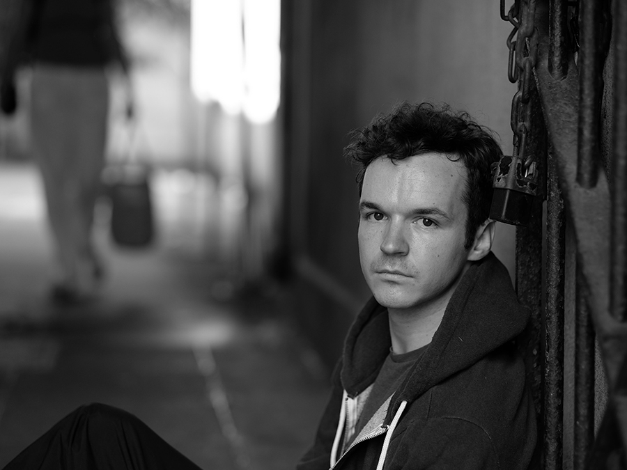 mental health condition - man looking into camera and sitting - black and white