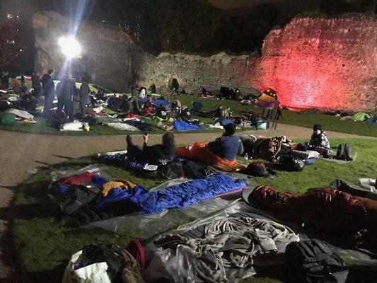people laying in on grass at night to raise money