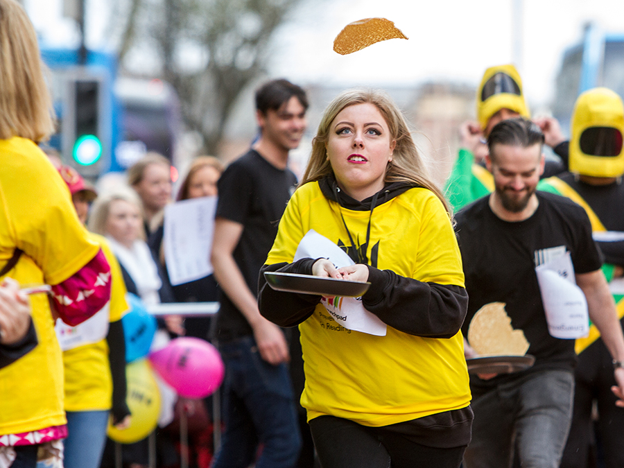 raise - woman flipping pancake in race