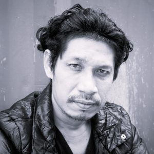 Man with black hair sitting