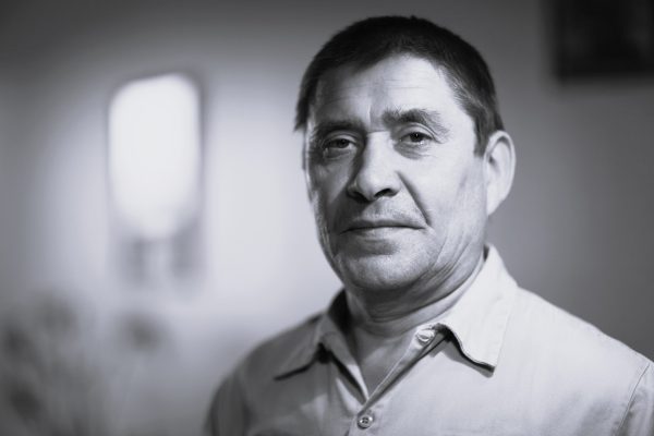 Head and shoulders of middle aged man with black hair