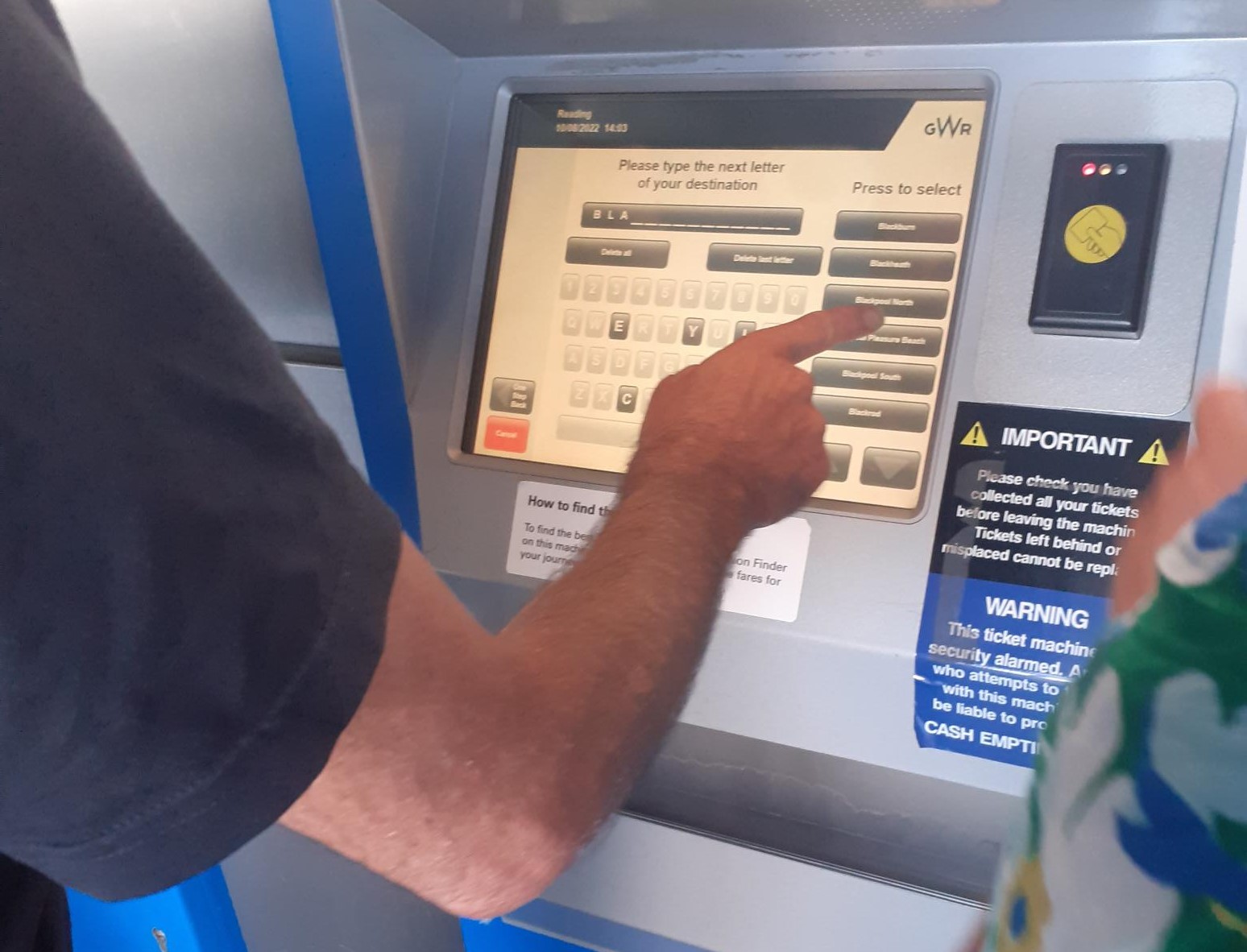 Hand on screen buying a train ticket