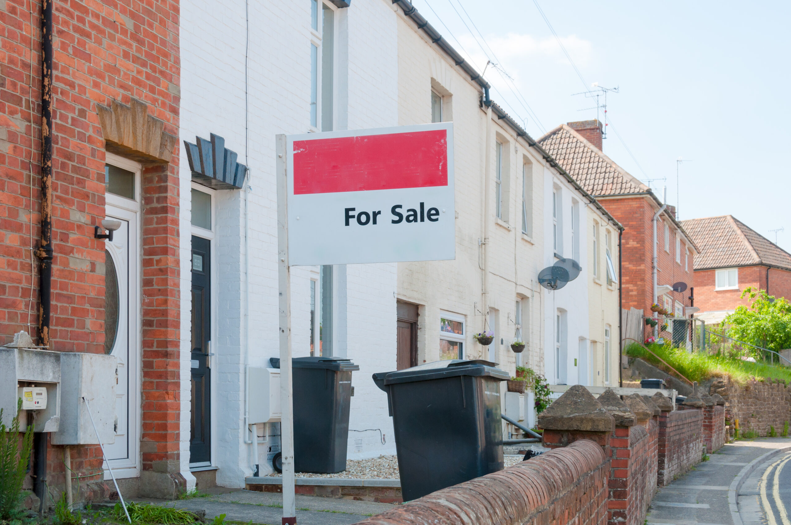 For sale sign in street of houses