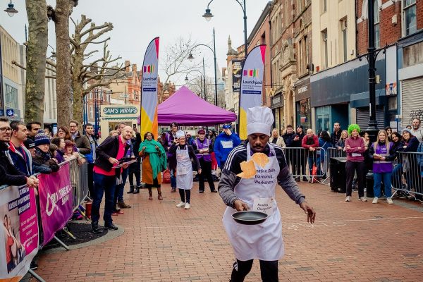 Photo from Launchpad's 2023 Pancake Race - man dressed as a chef flipping a pancake