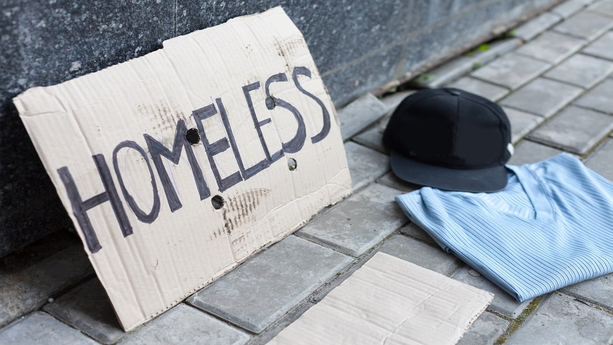 A written sign saying homeless