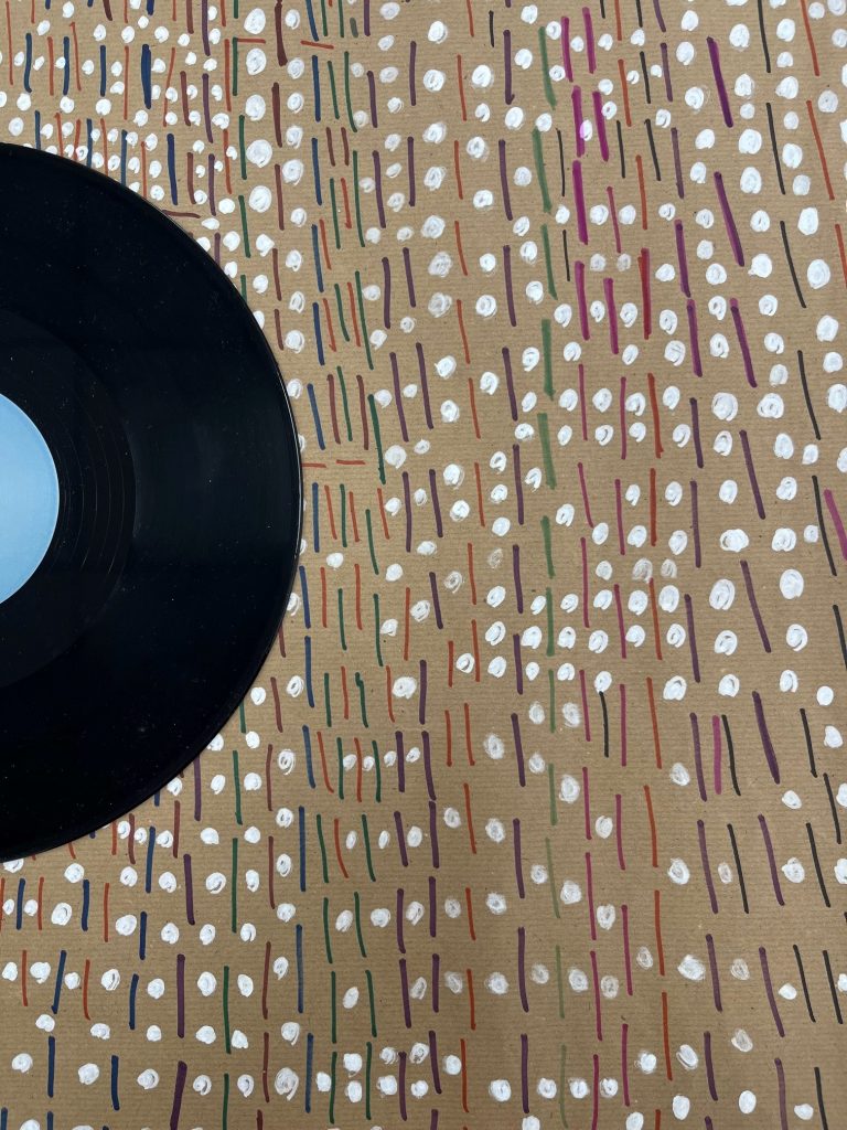 Artwork from the 2024 Launchpad 135 art exhibition - Black vinyl record on top of brown paper with white paint