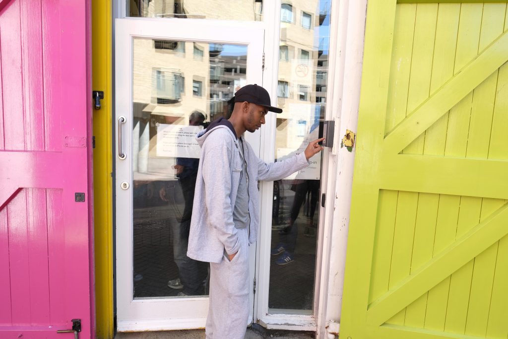 Stock Shot of a young man ringing the doorbell at the Launchpad office