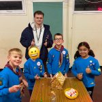 Max standing with beavers and gingerbread house