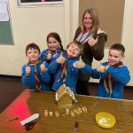 Fiona standing with Beavers and gingerbread house