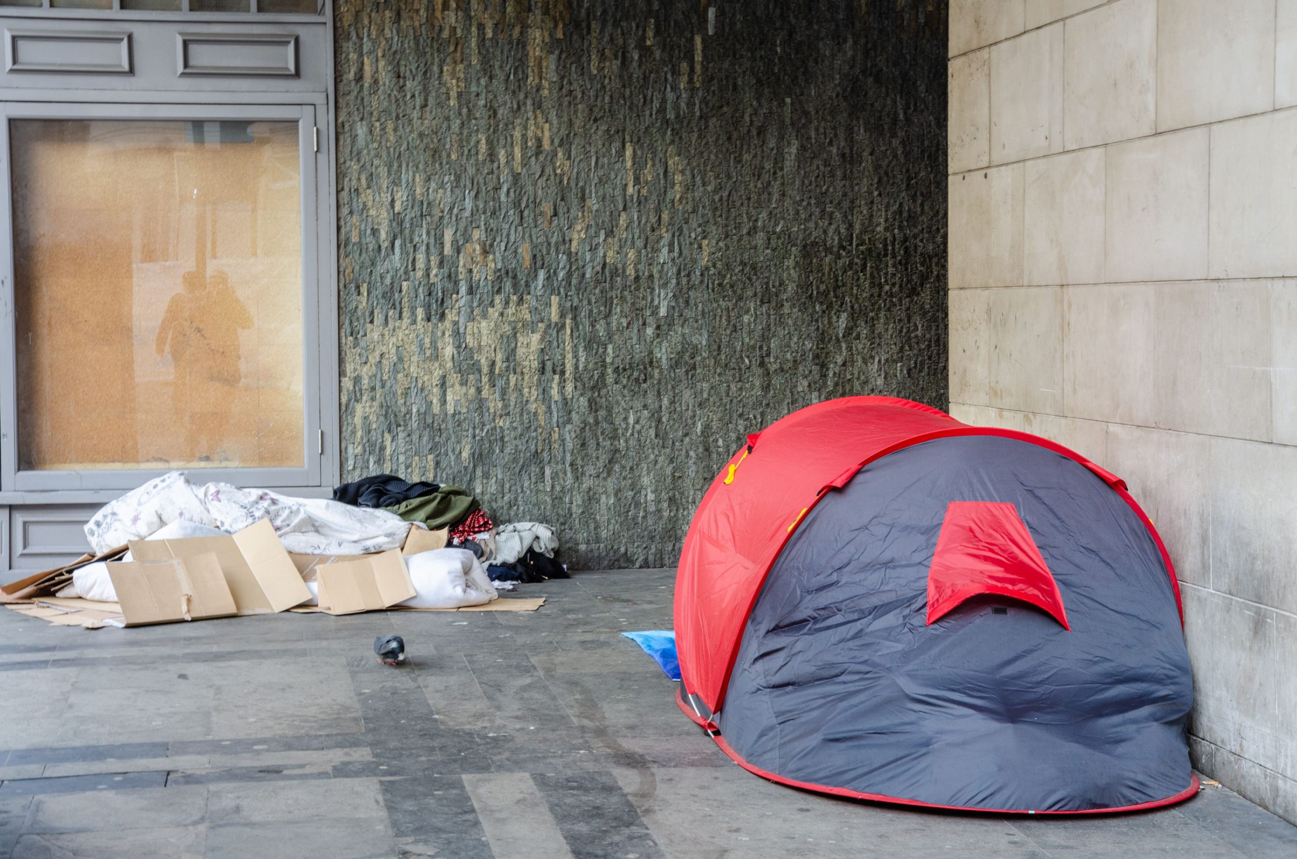 grey and red tent used by a rough sleeper