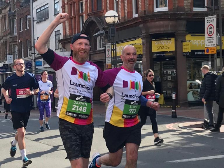 Two men taking part in the Reading Half Marathon. They are both wearing Launchpad running tops.