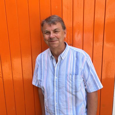 Steve in a blue shirt in front of an orange door