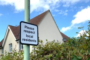 Picture of a sign post saying 'please respect local residents'
